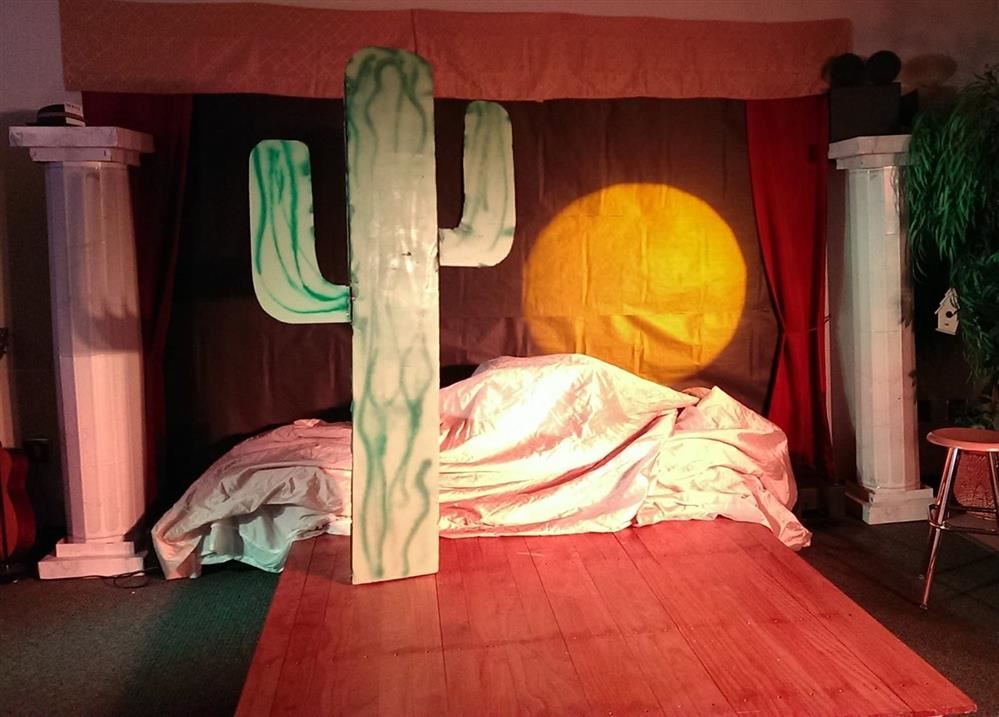 A stage with cactus and sunset.